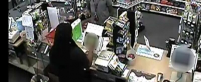 black man using stolen credit card at cash register