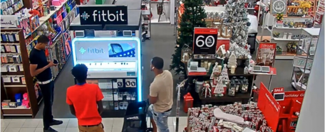 Three men standing in front of a fitbit display at kohl's