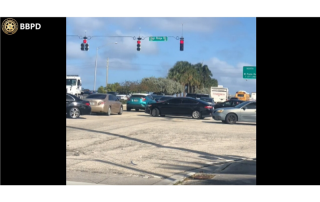 Cars stuck in traffic with a red traffic signal.