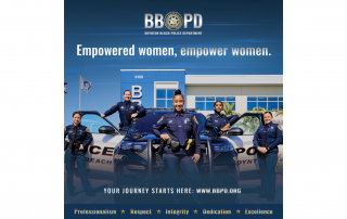 5 female police officers standing next to police car in front of police department