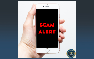 Hand holding a cell phone that shows scam alert on the screen